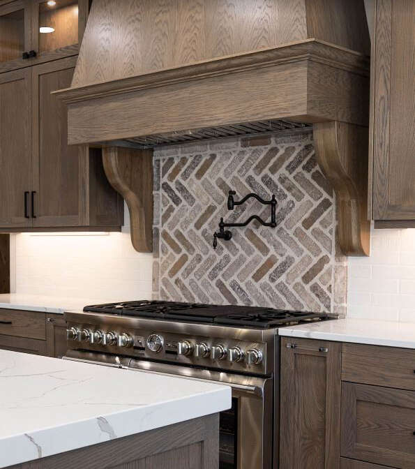 Kitchen renovation with range hood adorned by corbels